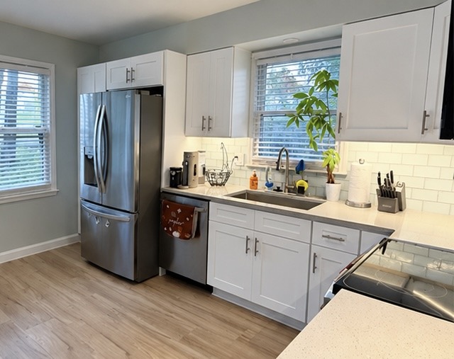 Gray Galaxy quartz countertop at the sink and window with White Shaker cabinets in a Belton, MO kitchen