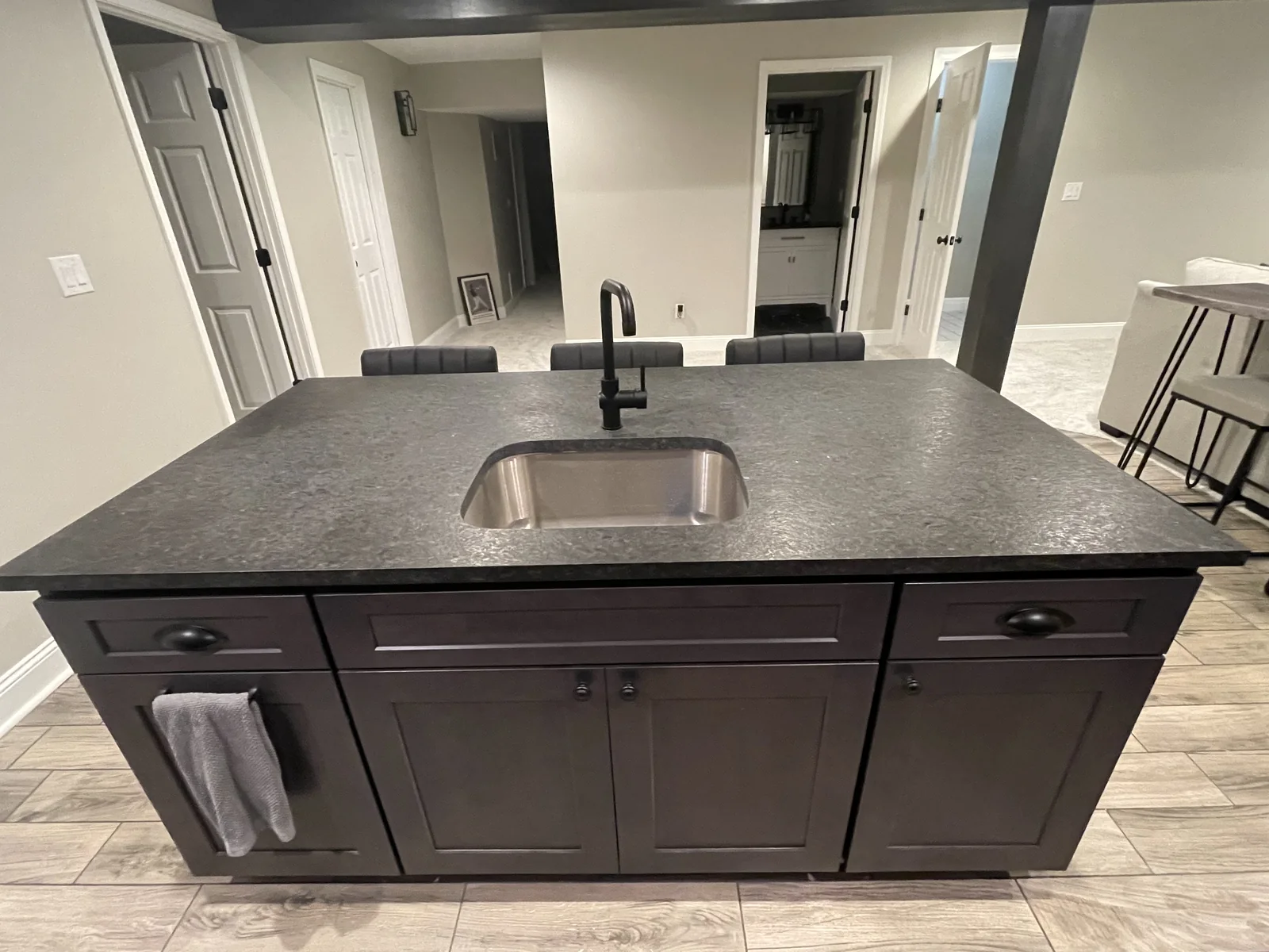 Gray granite kitchen island with dark cabinets and undermount sink in Kansas City