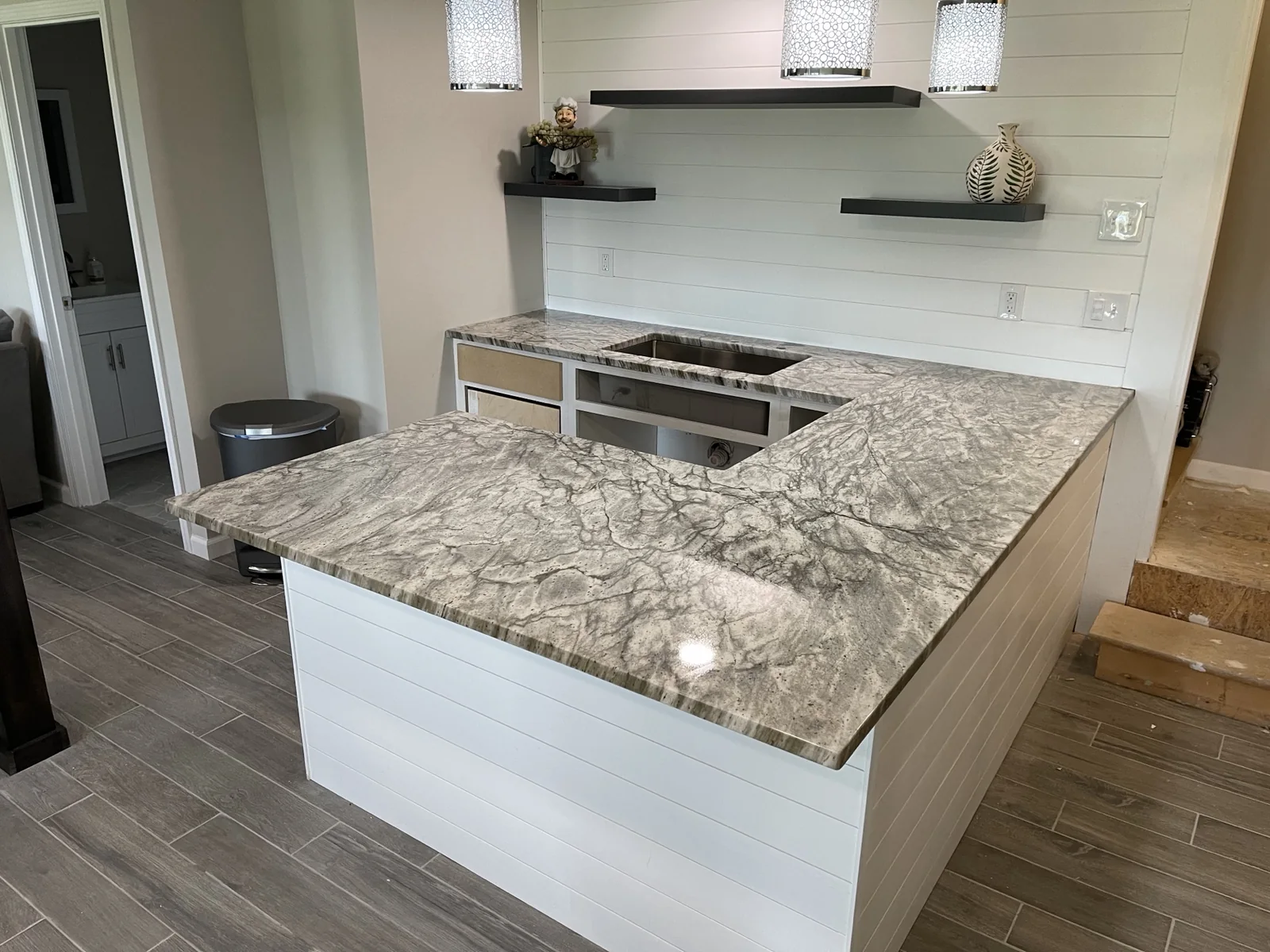 Gray granite U-shaped countertops with white cabinets installed in a Kansas City kitchen