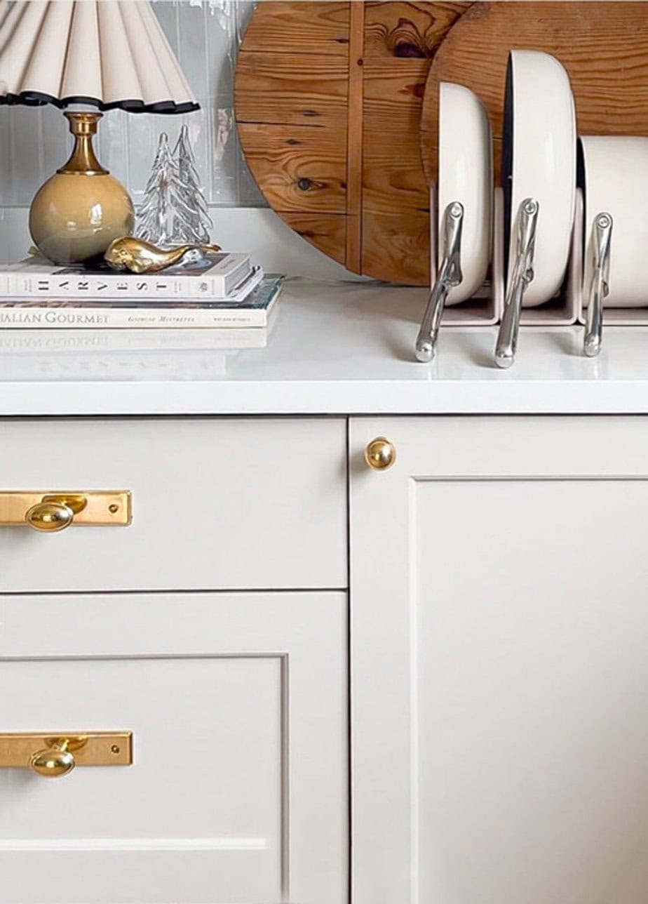 Cabinet hardware details and pull-out dish organizer installed in white cabinetry