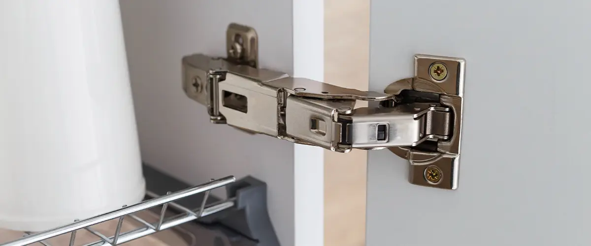 Close-up of a concealed soft-close kitchen cabinet hinge