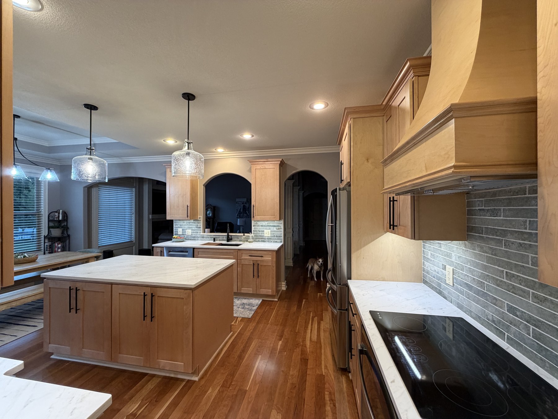 Wide view of the redesigned kitchen with quartz island and relocated cooktop, Lee's Summit, MO