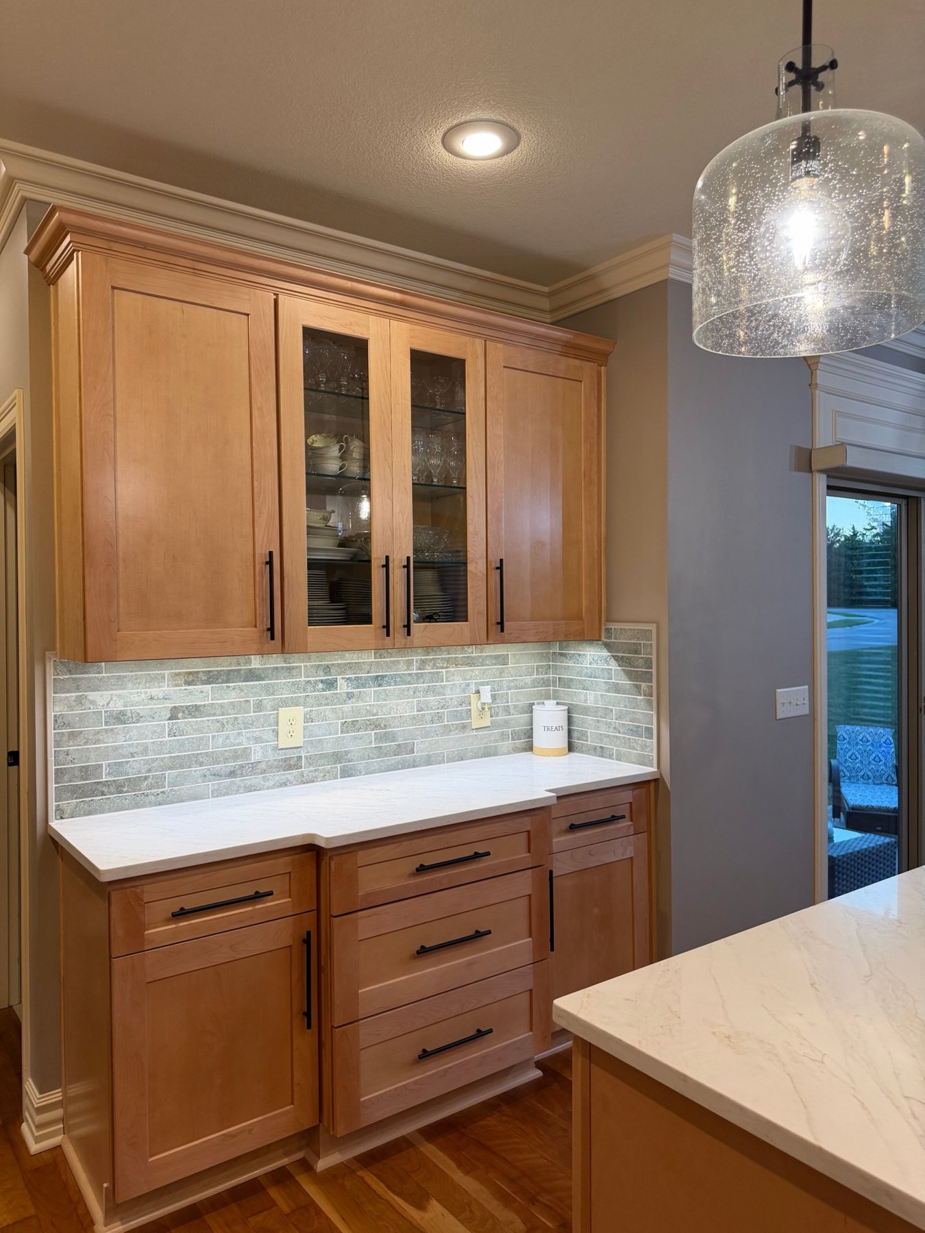 Glass-front maple hutch cabinet with under-cabinet lighting and tile backsplash, Lee's Summit, MO kitchen remodel