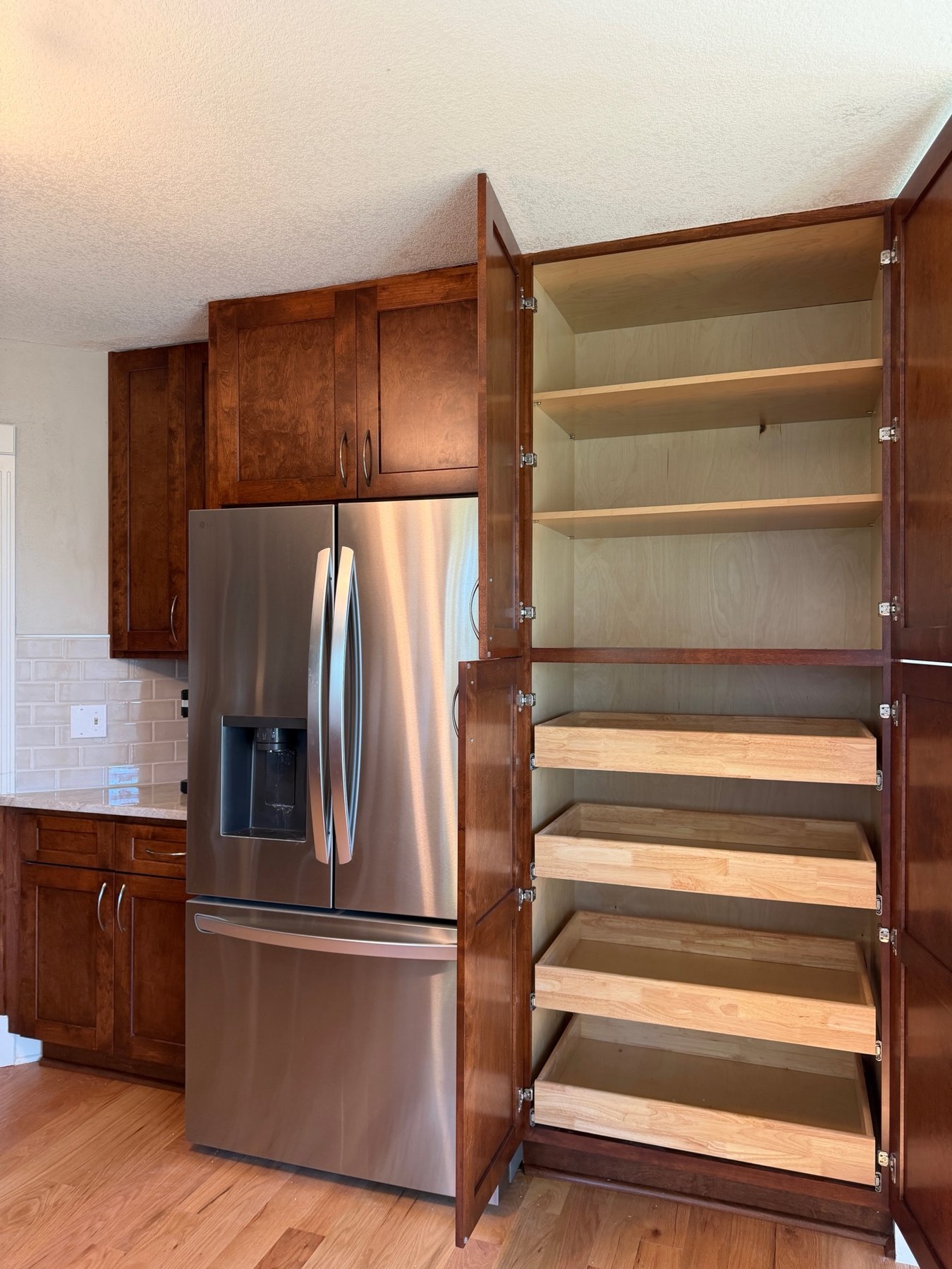Pantry with four pull-out shelves in a stained shaker cabinet, Liberty, MO kitchen remodel